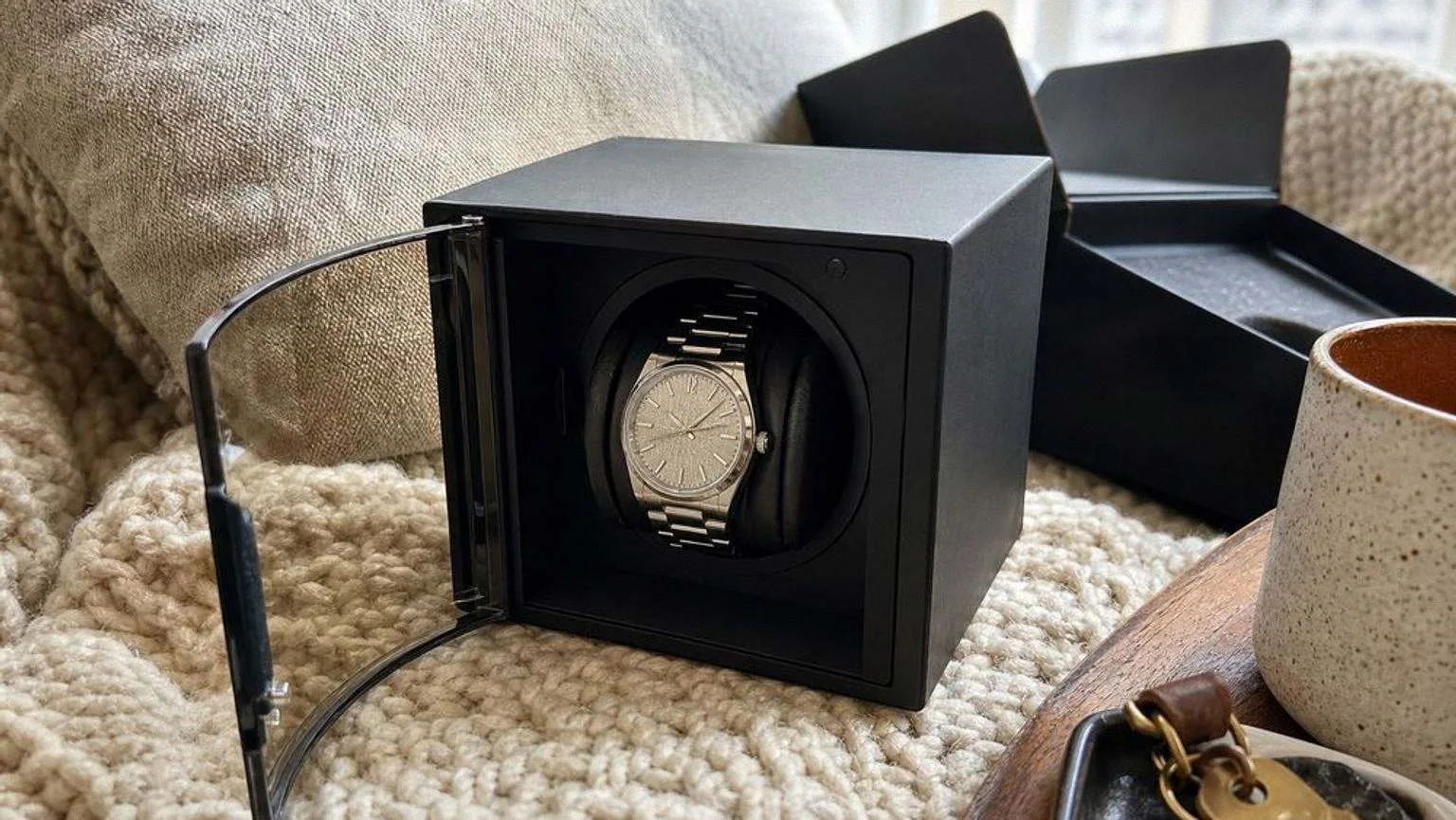 Winder de cubo con la puerta de cristal curvado abierta y un reloj de acero montado en el soporte giratorio